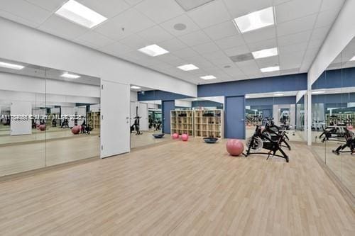 workout area with wood finished floors and a paneled ceiling