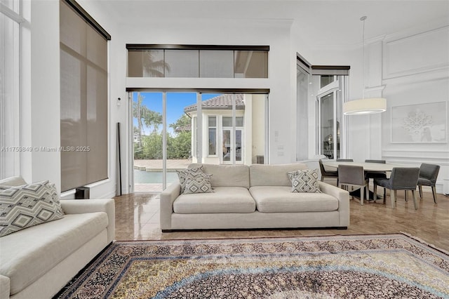 living area featuring crown molding and a decorative wall