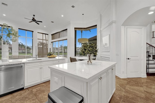 kitchen featuring visible vents, stainless steel dishwasher, white cabinets, a ceiling fan, and a sink