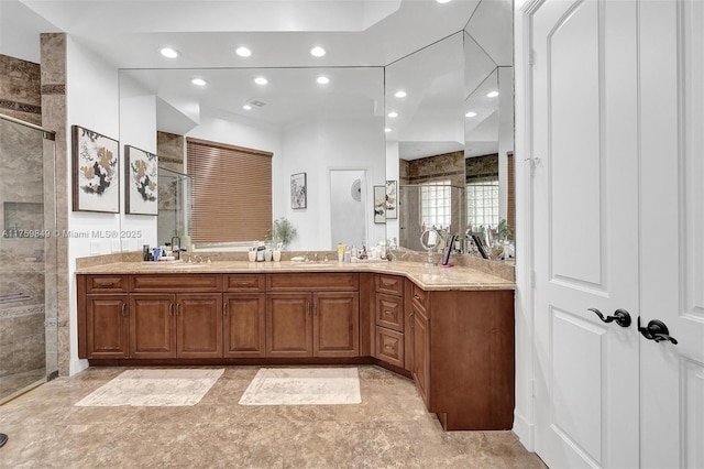 bathroom featuring a tile shower, recessed lighting, and vanity