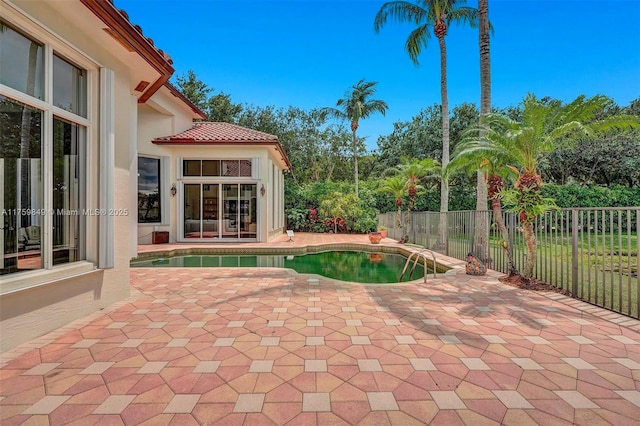 view of swimming pool featuring a patio, fence, and a fenced in pool