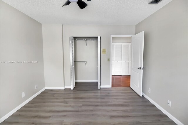 221 NW 201st Ave, Pembroke Pines, FL 33029 - unfurnished bedroom with wood finished floors, a textured ceiling, a closet, baseboards, and ceiling fan