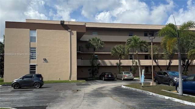 view of building exterior with uncovered parking