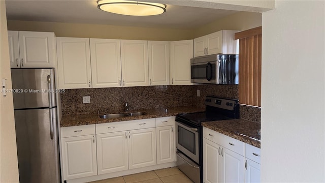 kitchen with a sink, tasteful backsplash, stainless steel appliances, white cabinets, and light tile patterned floors