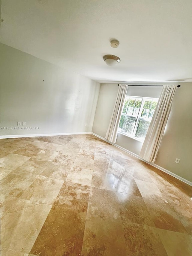 spare room featuring baseboards