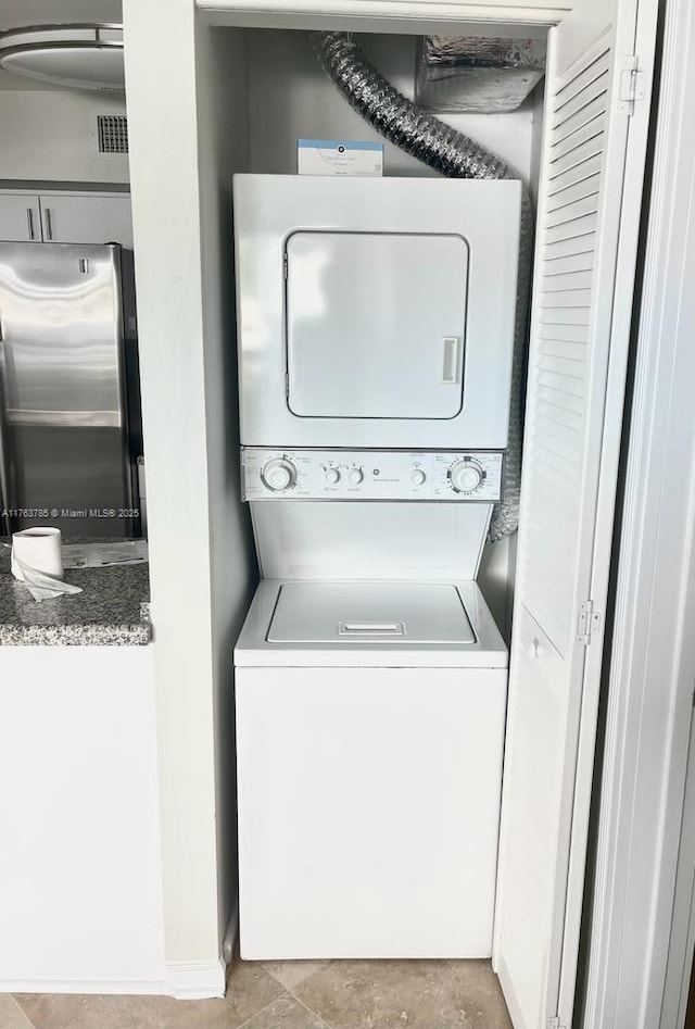 washroom featuring stacked washer and dryer and laundry area