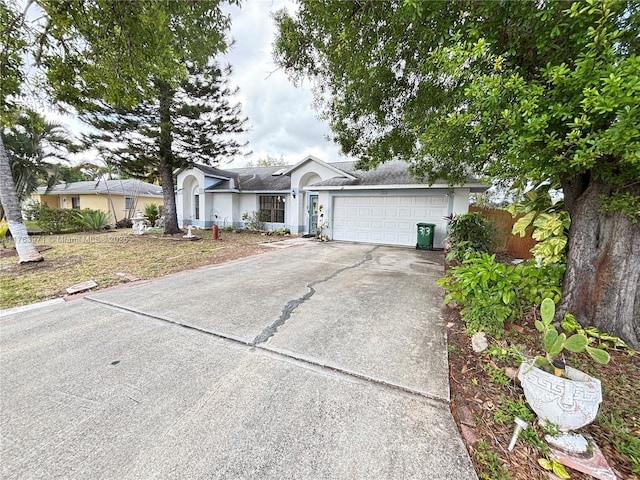 single story home with an attached garage, driveway, and stucco siding