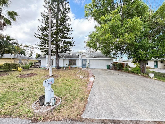 single story home featuring a garage, concrete driveway, and a front yard