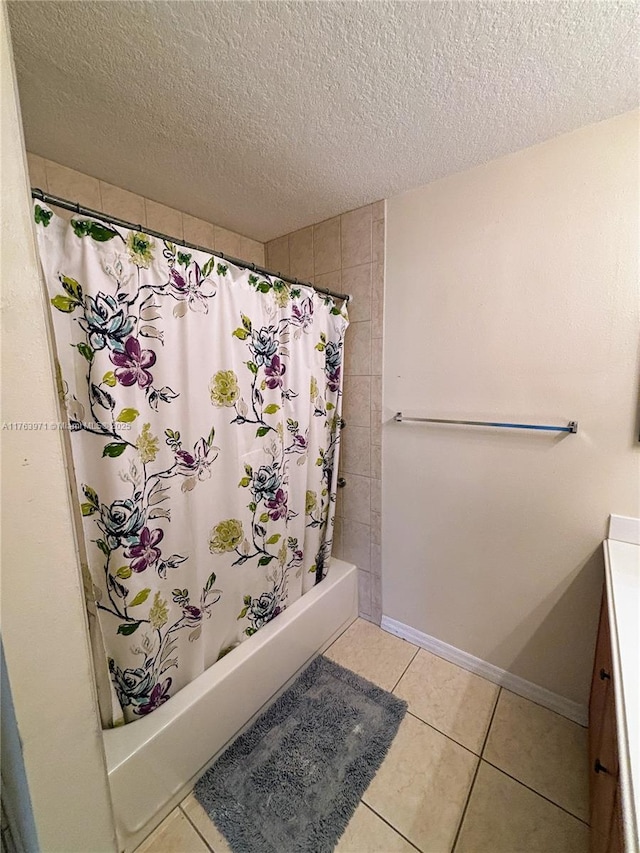 bathroom with baseboards, shower / tub combo with curtain, tile patterned floors, a textured ceiling, and vanity