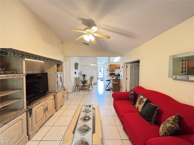 living area with visible vents, ceiling fan, vaulted ceiling, light tile patterned floors, and a textured ceiling