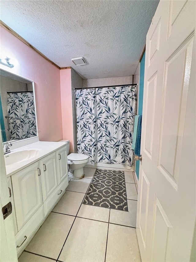 bathroom featuring tile patterned flooring, visible vents, toilet, vanity, and a textured ceiling