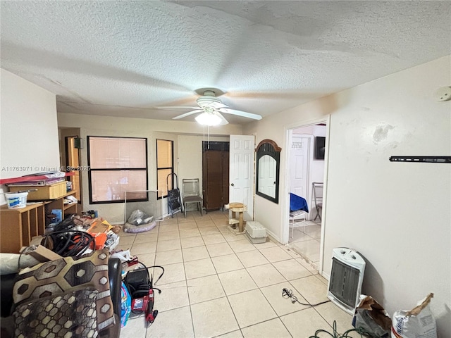 bedroom featuring light tile patterned floors, a textured ceiling, and ceiling fan