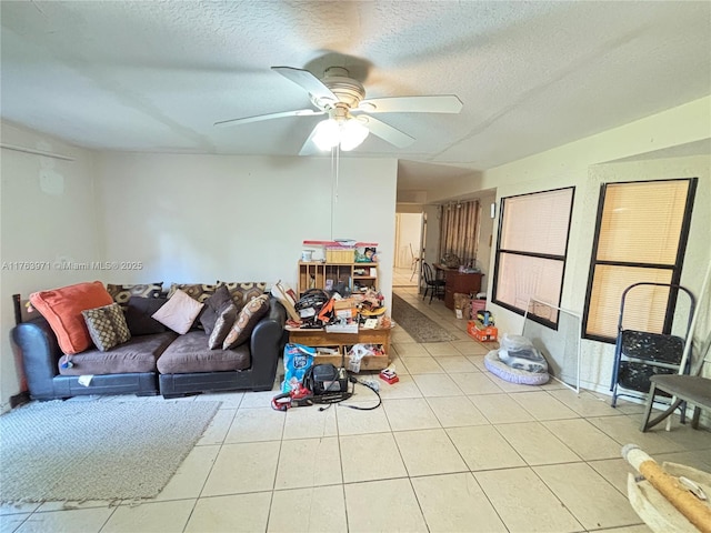 living area with tile patterned flooring, a textured ceiling, and a ceiling fan