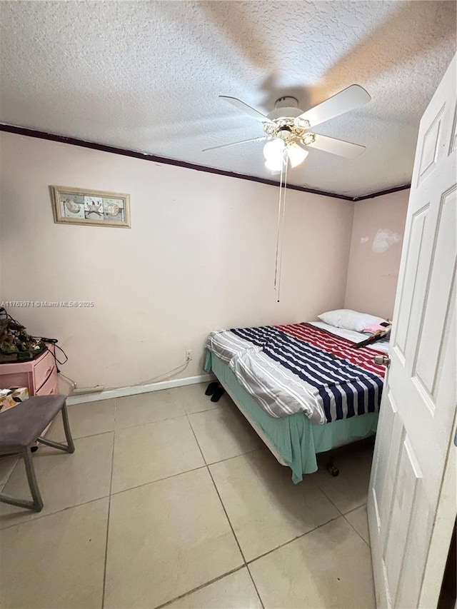 tiled bedroom featuring baseboards, a textured ceiling, and ceiling fan