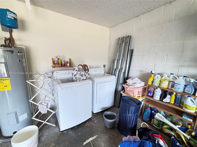 laundry room with electric water heater, laundry area, washer and dryer, a textured ceiling, and concrete block wall