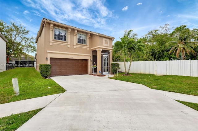 mediterranean / spanish-style home featuring a front lawn, fence, stucco siding, driveway, and an attached garage