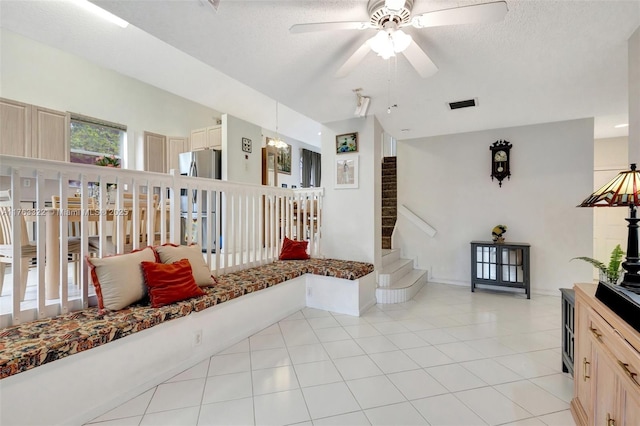 interior space featuring visible vents, baseboards, stairs, light tile patterned floors, and a textured ceiling