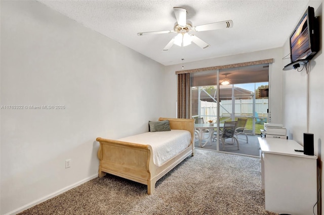 bedroom with a ceiling fan, a textured ceiling, carpet floors, baseboards, and access to exterior