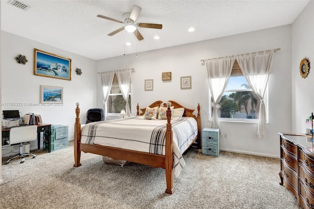 bedroom featuring visible vents, a textured ceiling, baseboards, and carpet