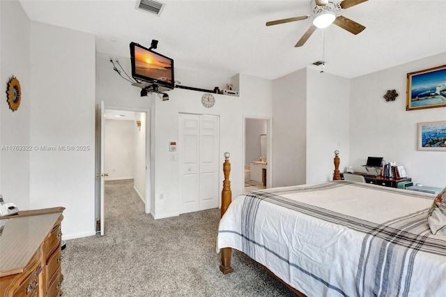 carpeted bedroom with visible vents, ceiling fan, ensuite bathroom, and baseboards