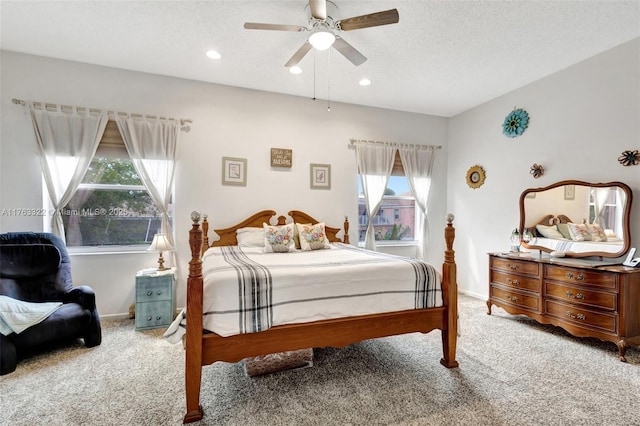 bedroom with multiple windows, carpet floors, and a textured ceiling