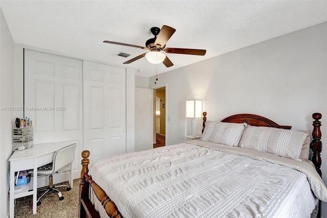 carpeted bedroom featuring visible vents, a textured ceiling, a closet, and ceiling fan