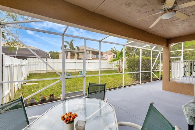 unfurnished sunroom featuring ceiling fan