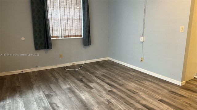 empty room featuring wood finished floors and baseboards