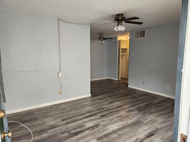 empty room with visible vents, baseboards, dark wood-style floors, and a ceiling fan