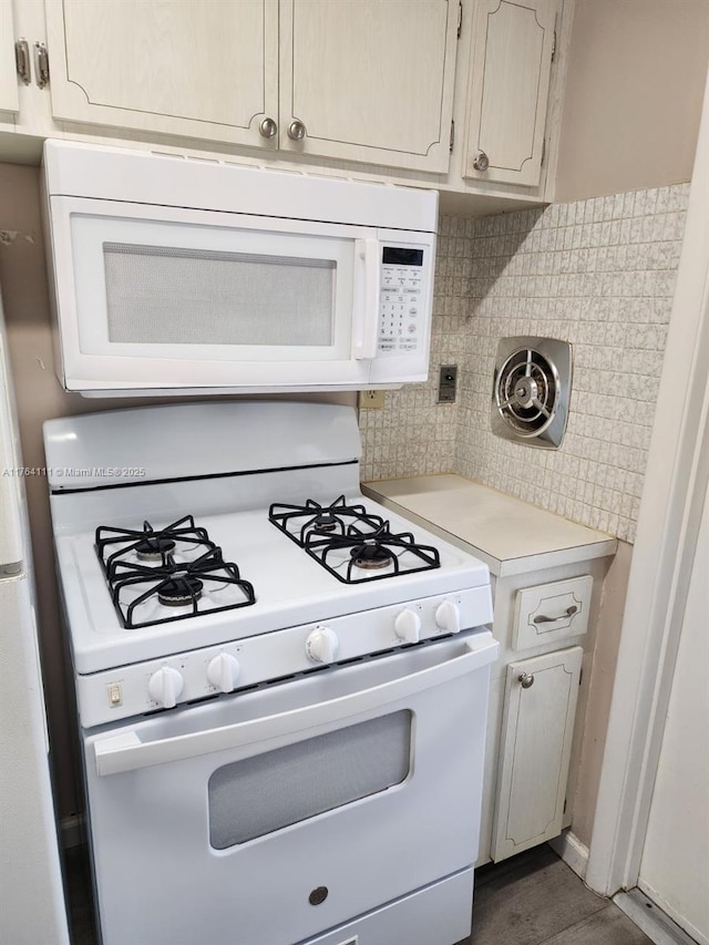 kitchen featuring white appliances, light countertops, and backsplash