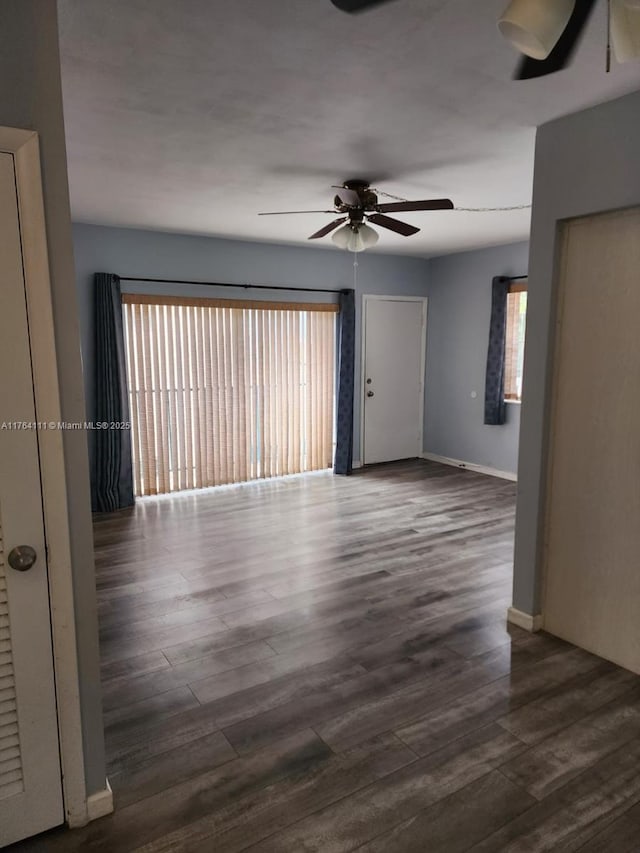 empty room with baseboards, ceiling fan, and wood finished floors