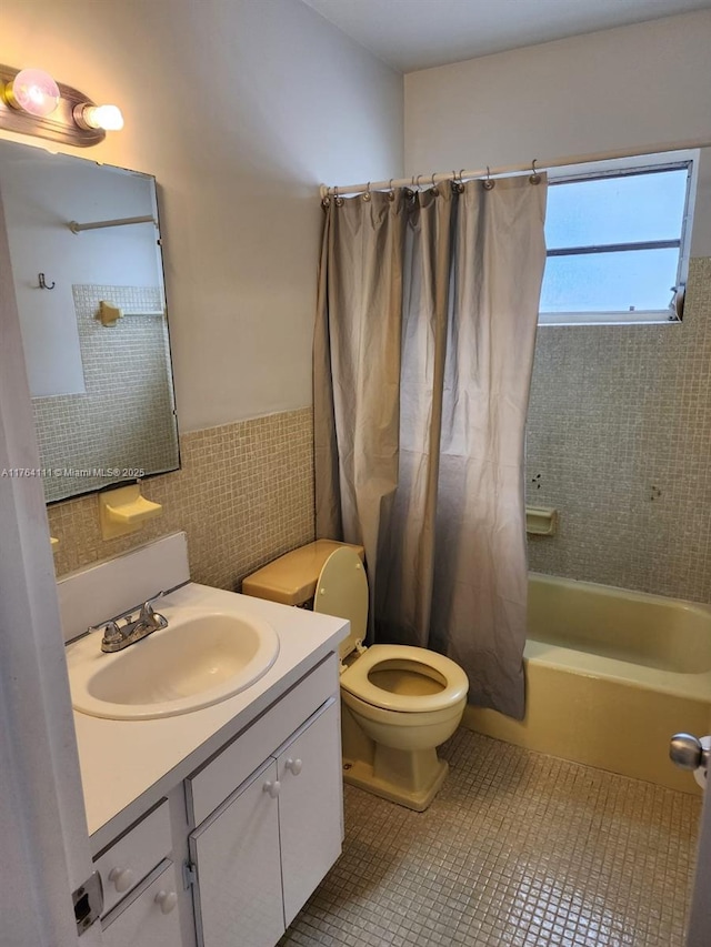 full bathroom featuring tile walls, toilet, shower / tub combo with curtain, tile patterned floors, and vanity