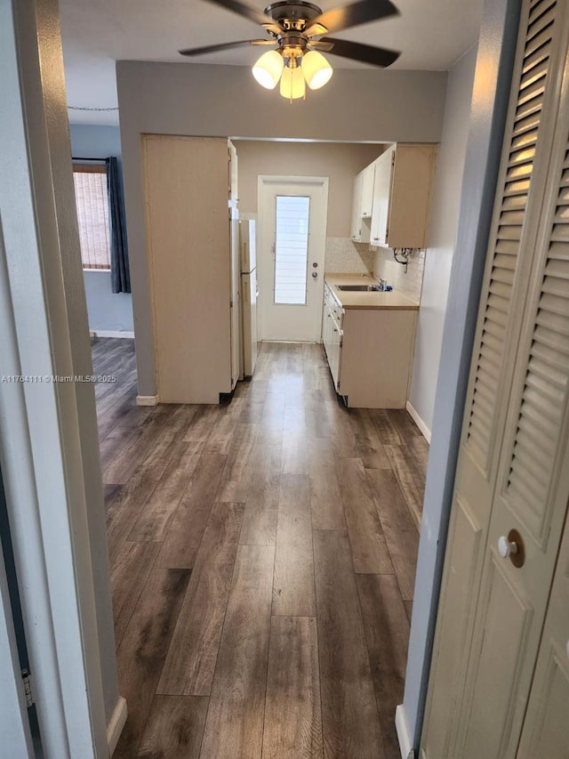 kitchen featuring wood finished floors, freestanding refrigerator, ceiling fan, light countertops, and backsplash