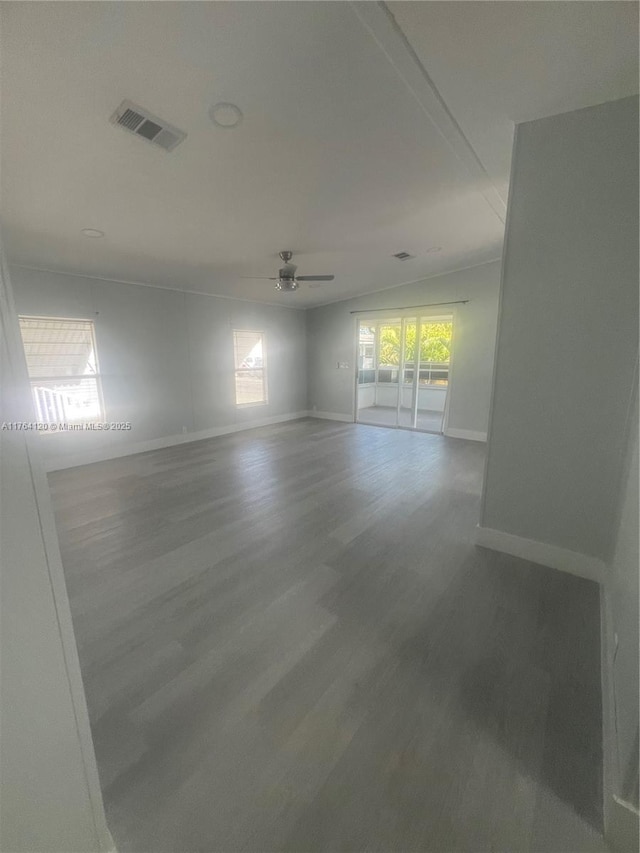 unfurnished room with visible vents, baseboards, ceiling fan, and wood finished floors