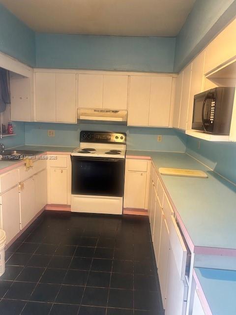 kitchen with range with electric cooktop, light countertops, white cabinets, black microwave, and under cabinet range hood