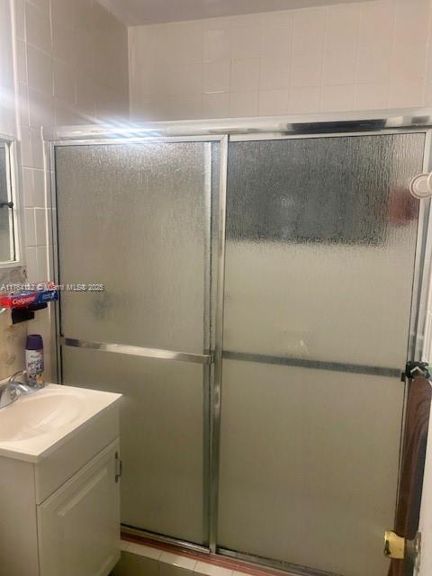 full bath with a stall shower and vanity