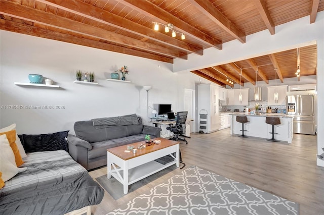 living area with light wood finished floors, beamed ceiling, and wooden ceiling