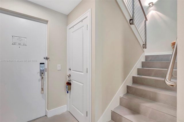 entryway with stairway and baseboards