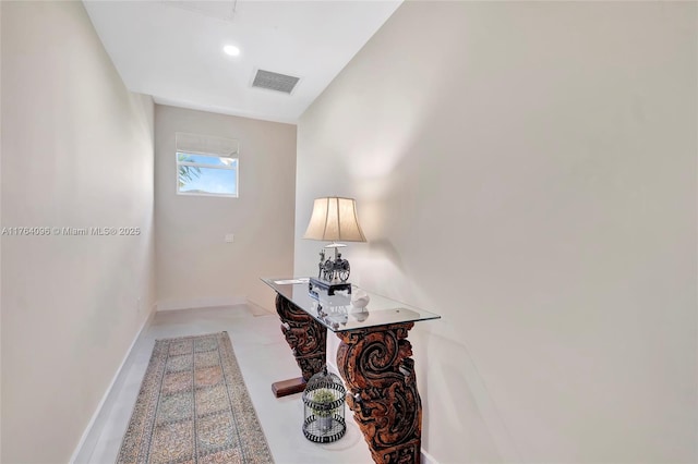 hallway featuring baseboards and visible vents