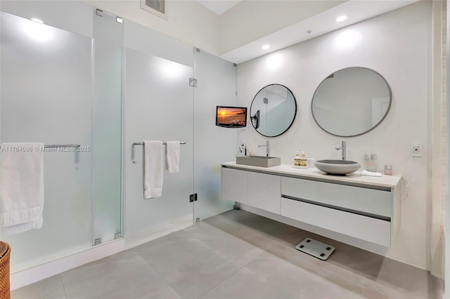 full bathroom featuring a sink, visible vents, double vanity, and a shower stall