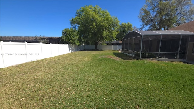 view of yard featuring glass enclosure and a fenced backyard