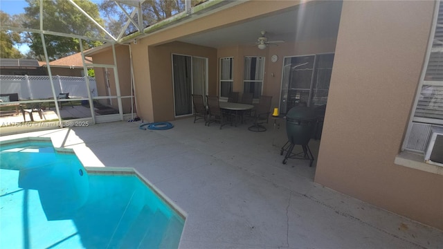 view of swimming pool featuring a fenced in pool, ceiling fan, fence, a lanai, and a patio