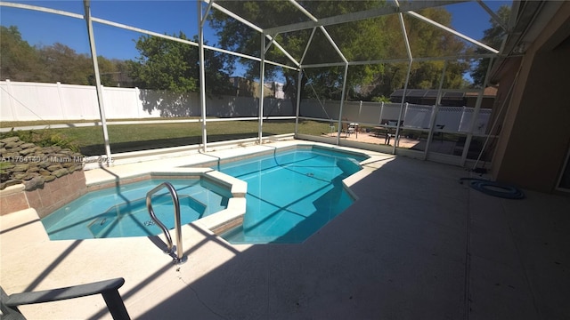 view of swimming pool featuring a patio area, glass enclosure, a pool with connected hot tub, and a fenced backyard