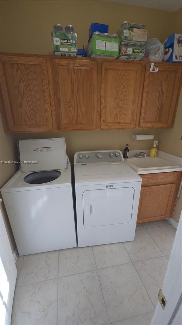 laundry area with separate washer and dryer, cabinet space, marble finish floor, and a sink