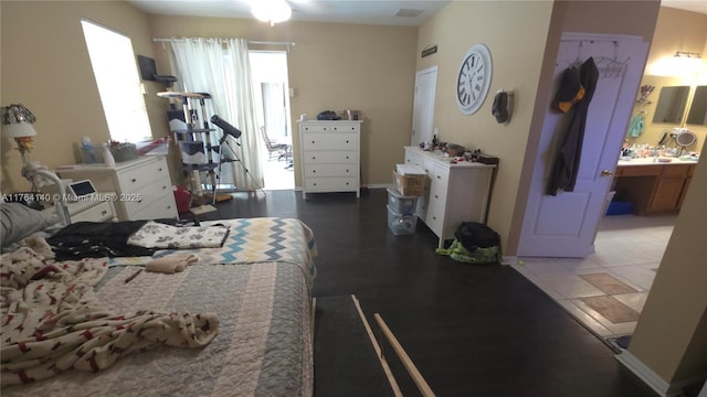 bedroom with ensuite bathroom and baseboards