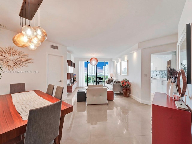 dining space featuring light tile patterned floors, visible vents, and baseboards