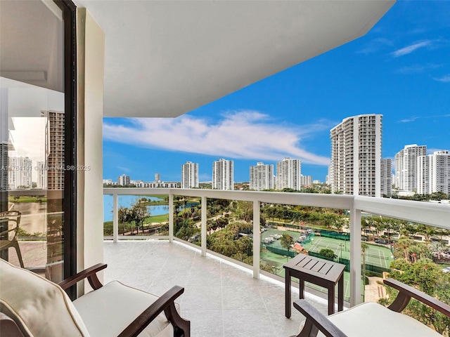 balcony featuring a water view and a city view