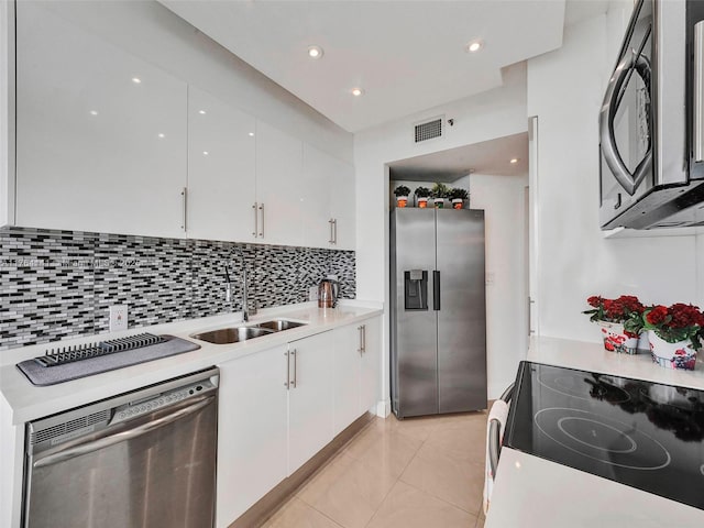 kitchen featuring a sink, stainless steel appliances, white cabinets, and light countertops