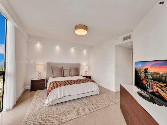 bedroom featuring light tile patterned floors, visible vents, and baseboards