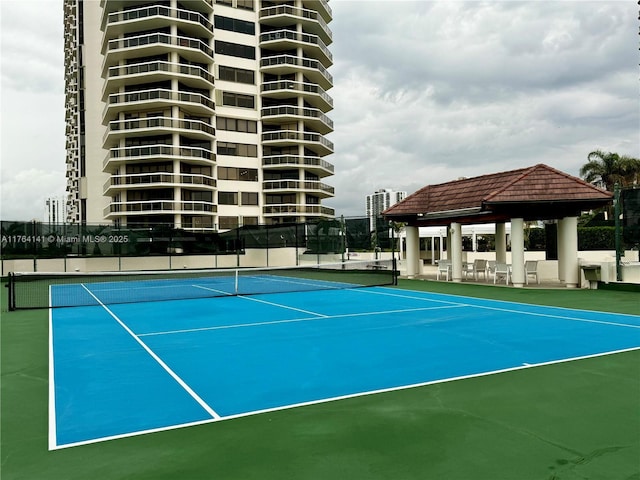 view of tennis court featuring a gazebo and fence